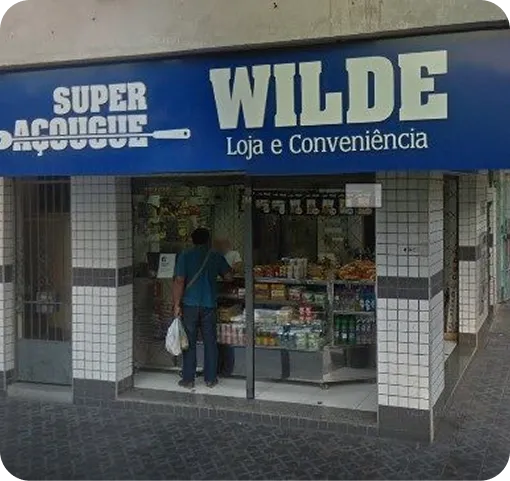 Fachada do Super Açougue Wilde, com faixa azul e azulejo branco